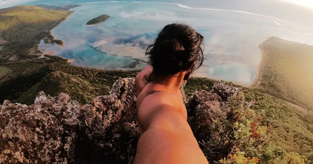 High angle view of shirtless man standing on cliff