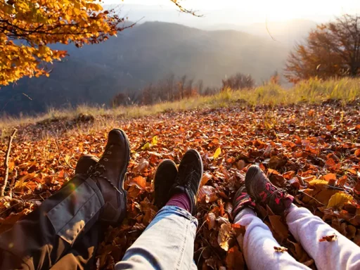 Low section of people on leaves during autumn